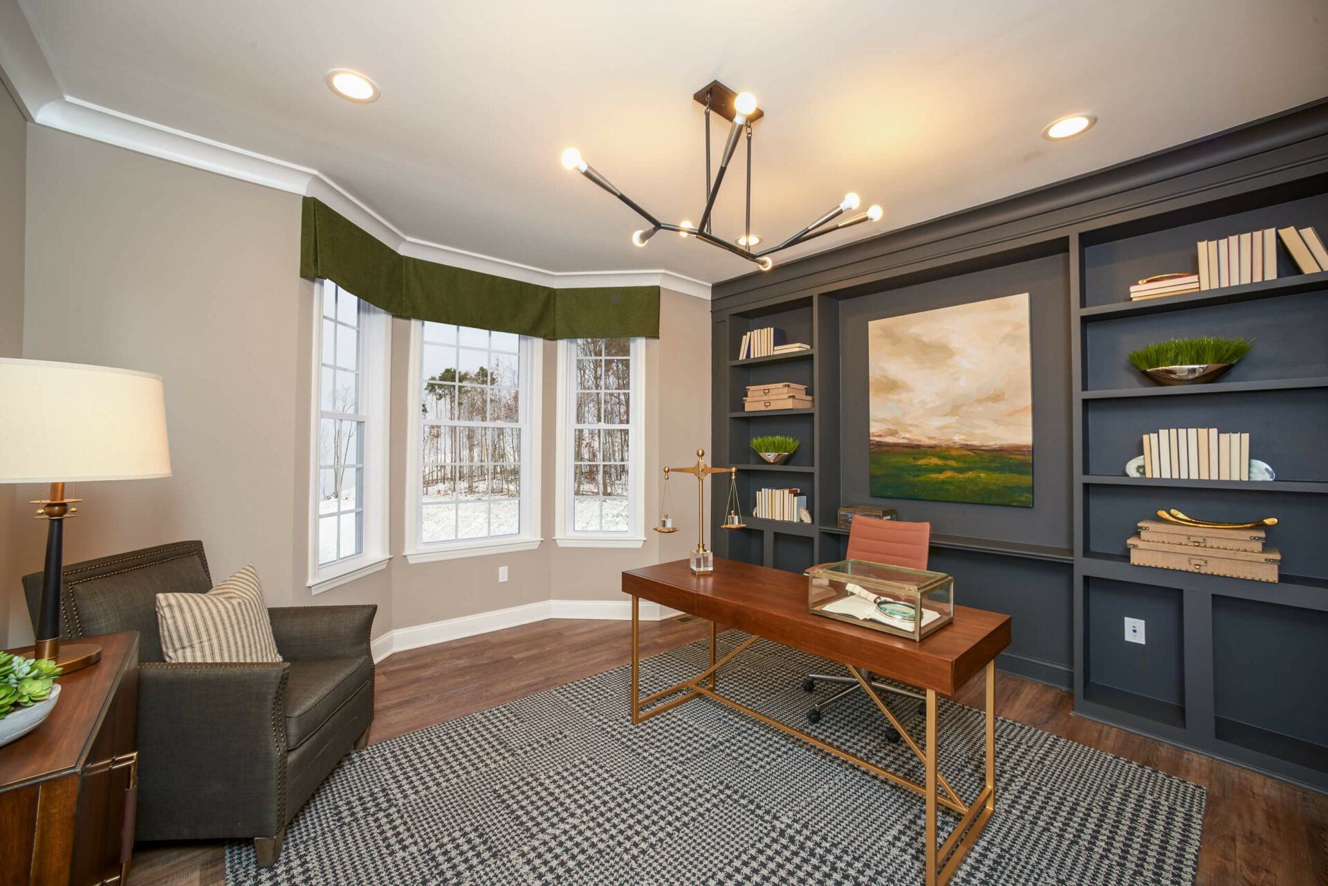 The office or den is smartly finished with a wall of richly-colored custom built-ins for books and more in the Hancock Model