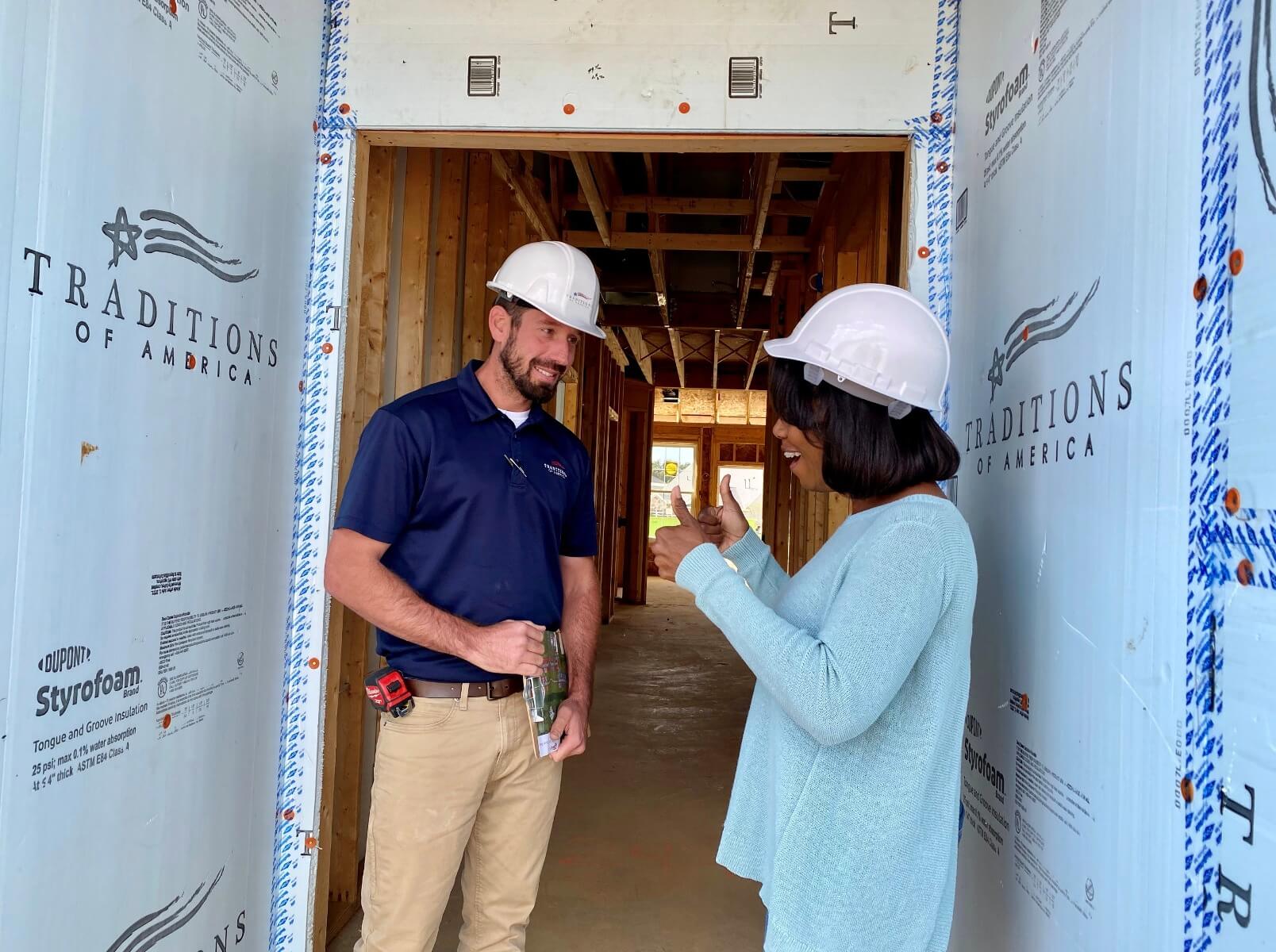 two people standing inside an under-construction home