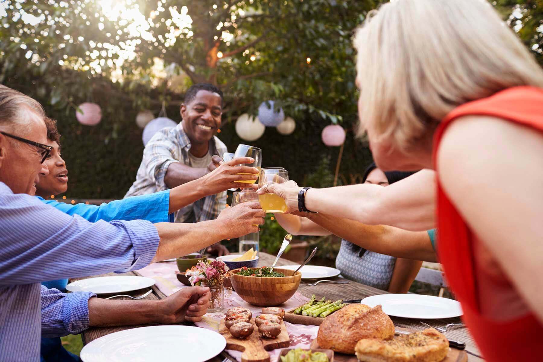 People toasting over the table during outdoor lunch
