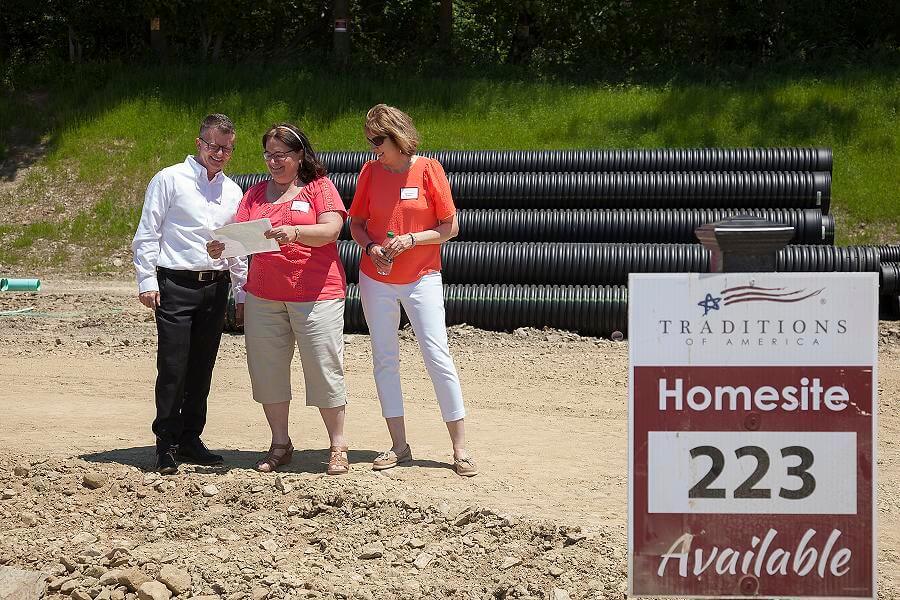 People standing on a homesite from traditions of america