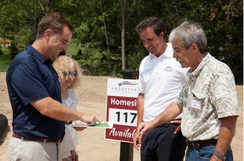 People standing on an empty homesite from Traditions of America