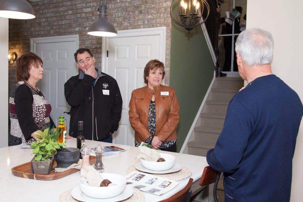 People talking in the kitchen of a summer seat model home