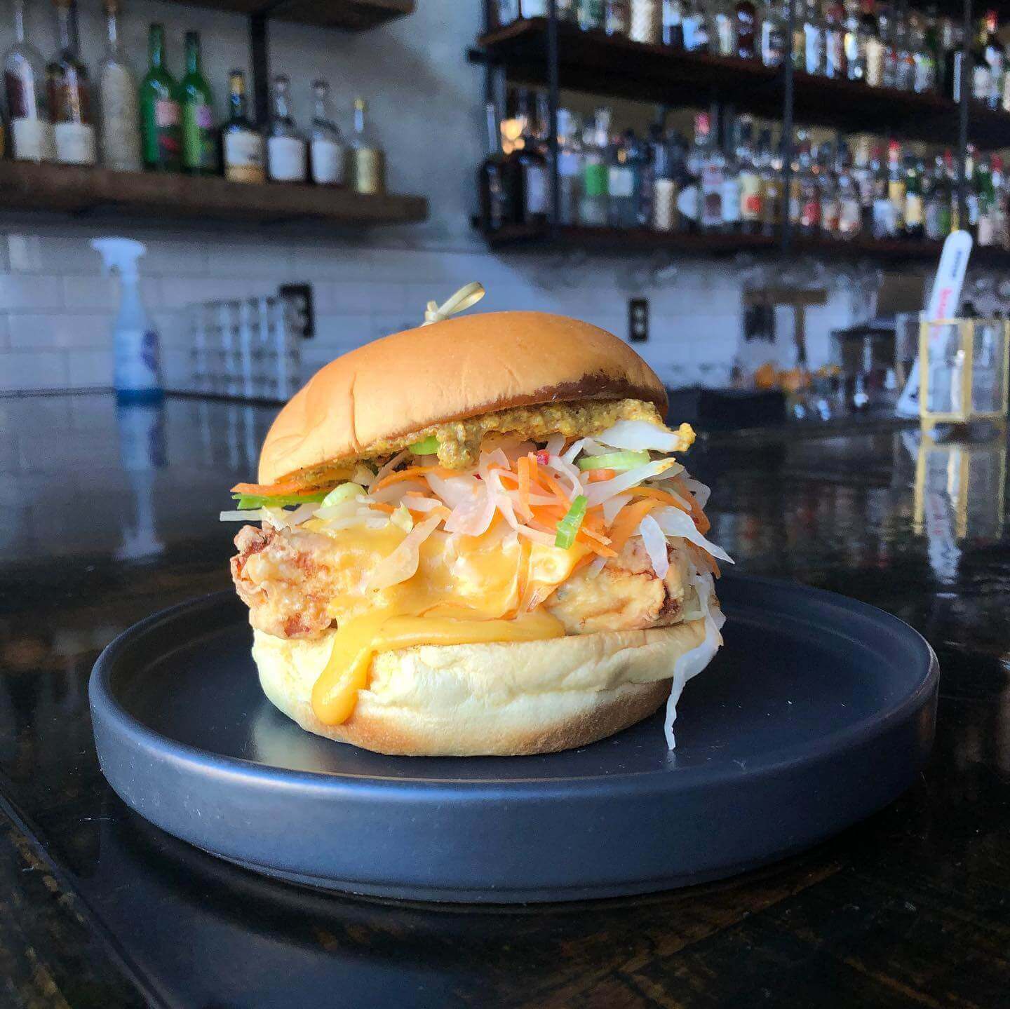 Sandwich on a black plate at the bar at Saison Market in Richmond, Virginia