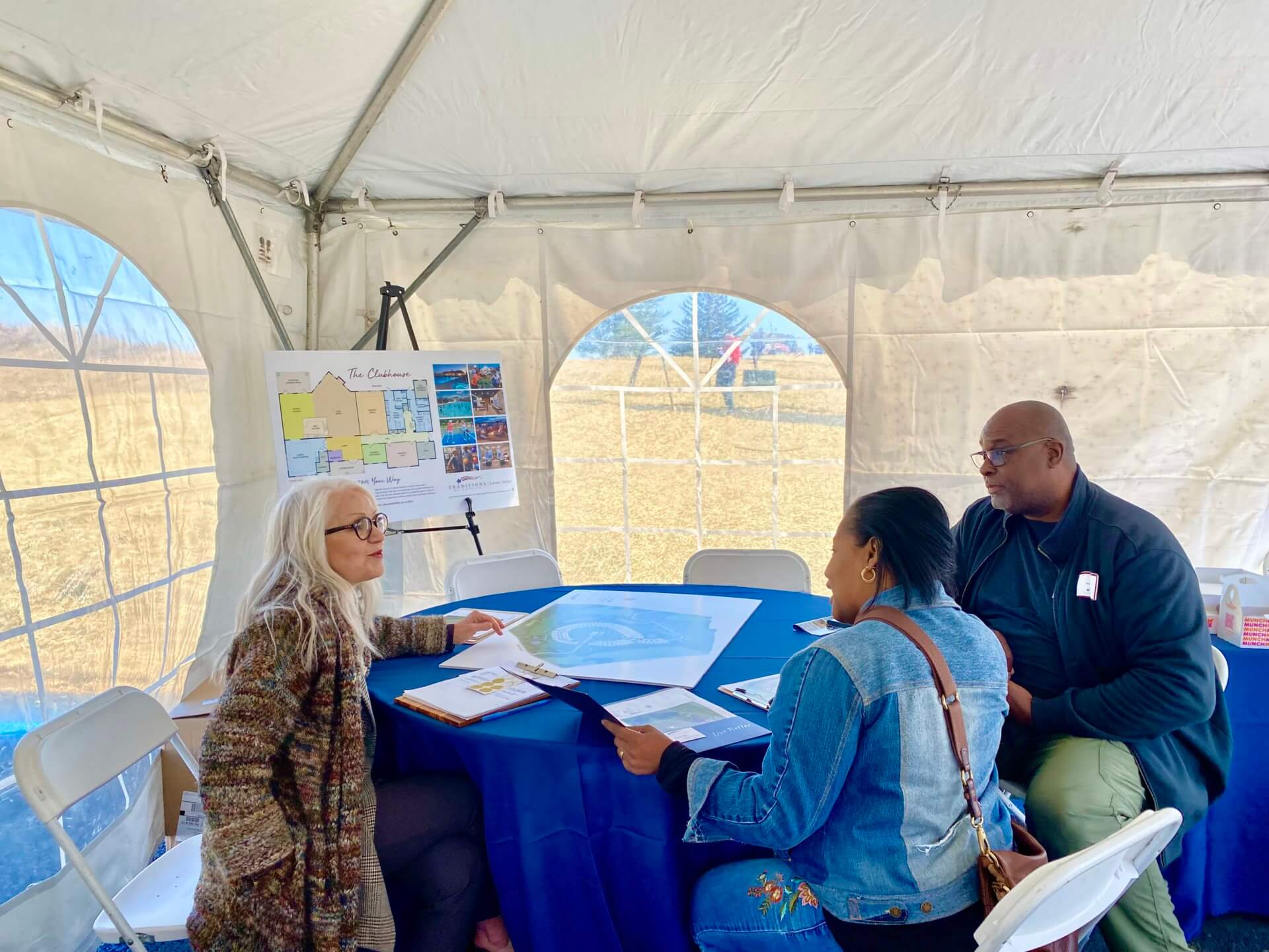People talking to a Traditions of America sales person in a tent