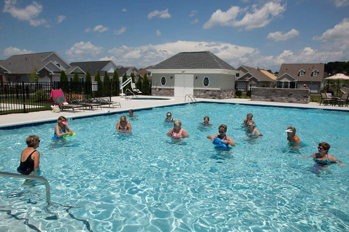 People in the pool at a Traditions of America clubhouse