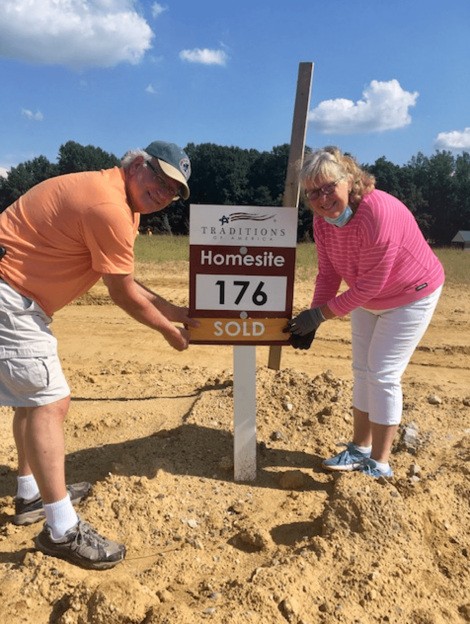 People standing on an empty homesite from Traditions of America