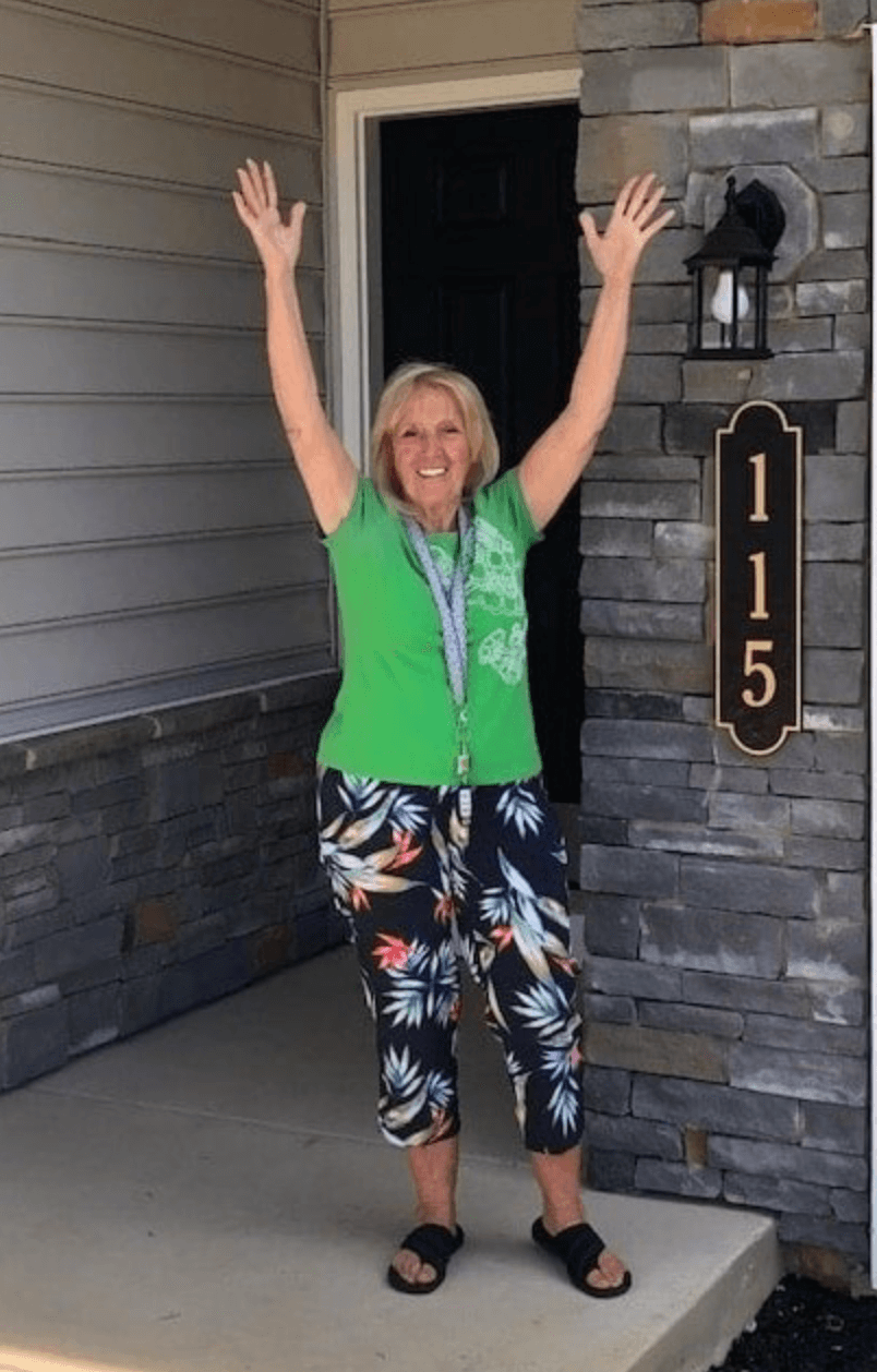 Woman standing in front of the front door of her new home