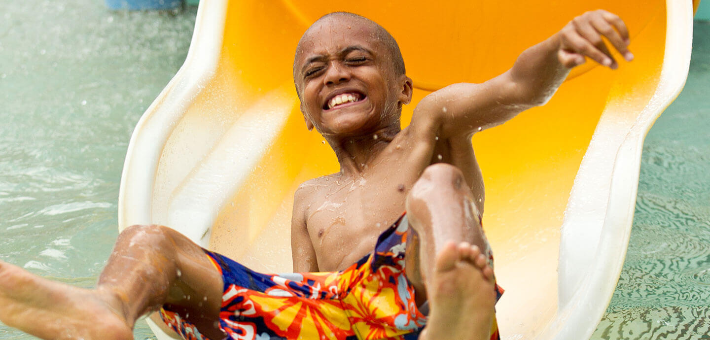 Kid sliding out of a water slide at the Water Park at Kings Dominion