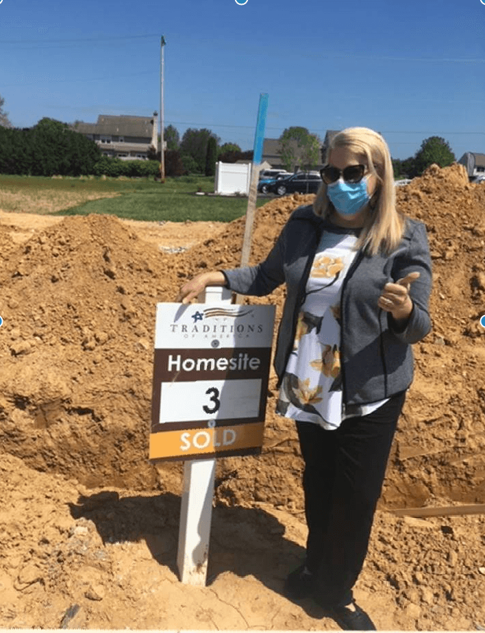 Person standing on an under construction Traditions of America homesite
