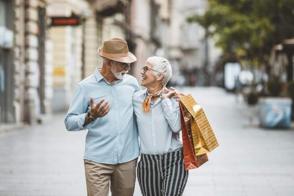 An active adult couple walking down the side walk in a city