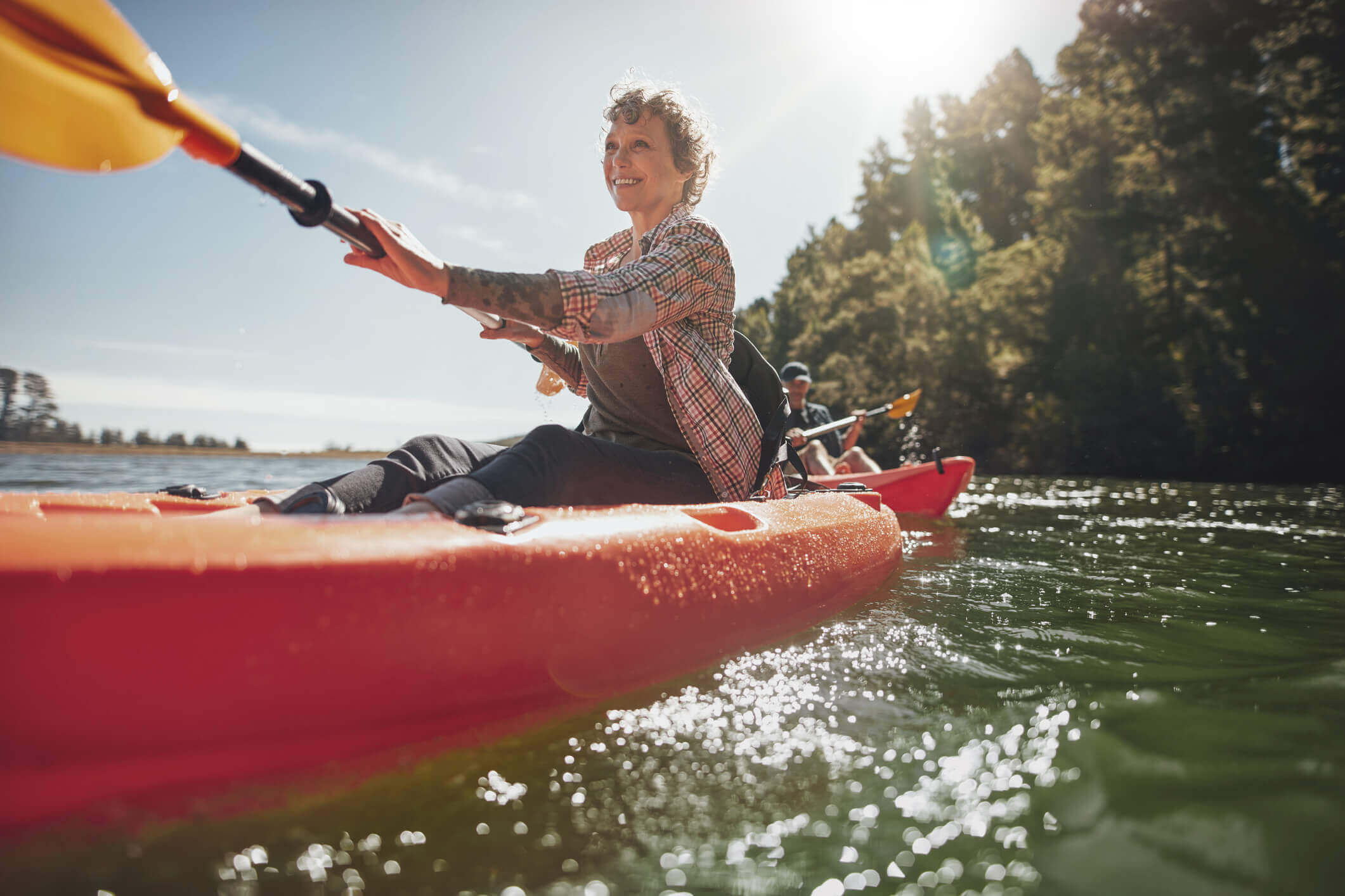 Active adult woman kayaking on a river
