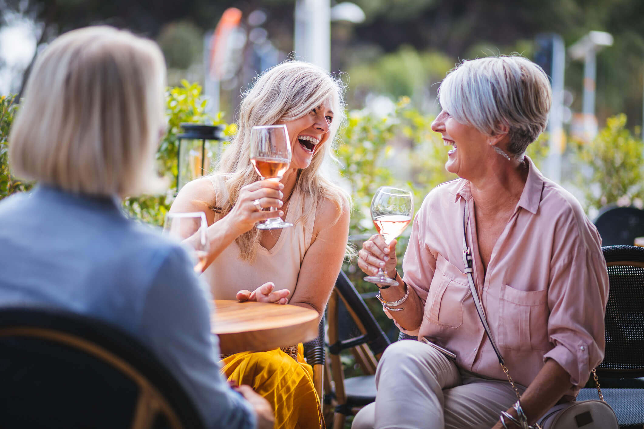 Three woman enjoying win outside at a restaurant 