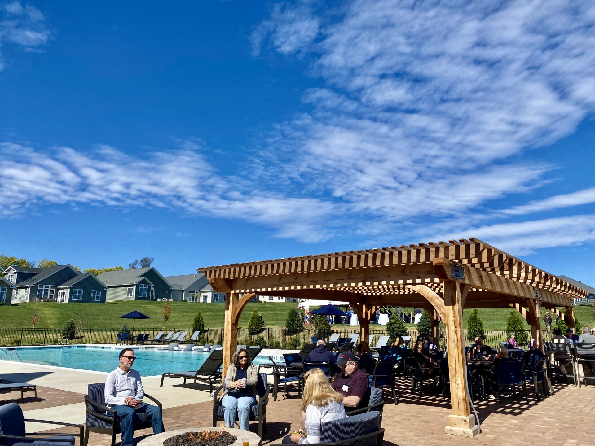 people sitting by the clubhouse pool in east petersburg from traditions of america