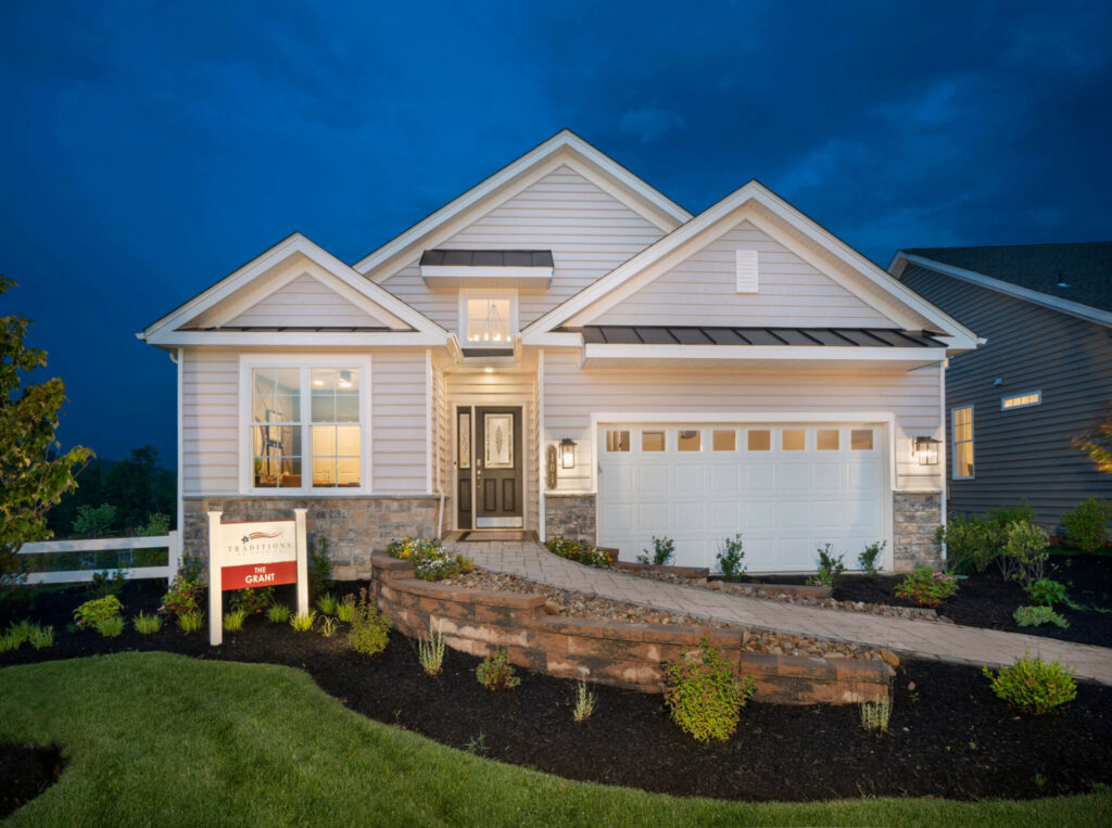 Front elevation of the Grant model with white siding and stone accents